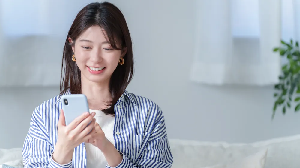 スマートフォンを操作する女性の画像