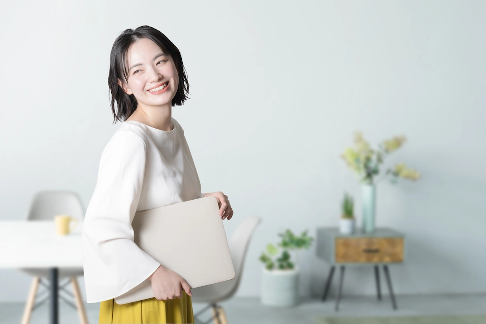 ノートパソコンを持つ女性の画像