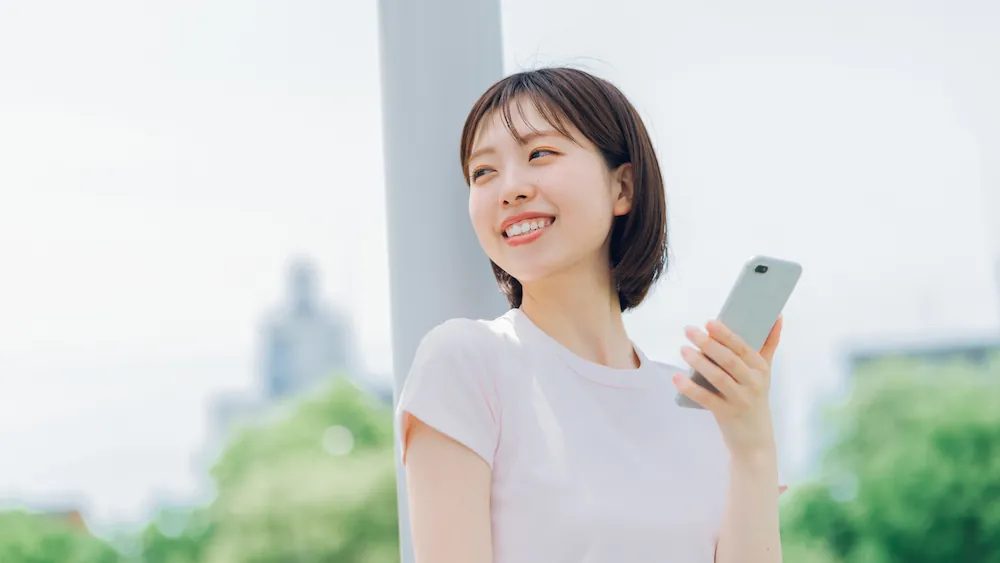 スマートフォンでインターネットを利用する女性の画像