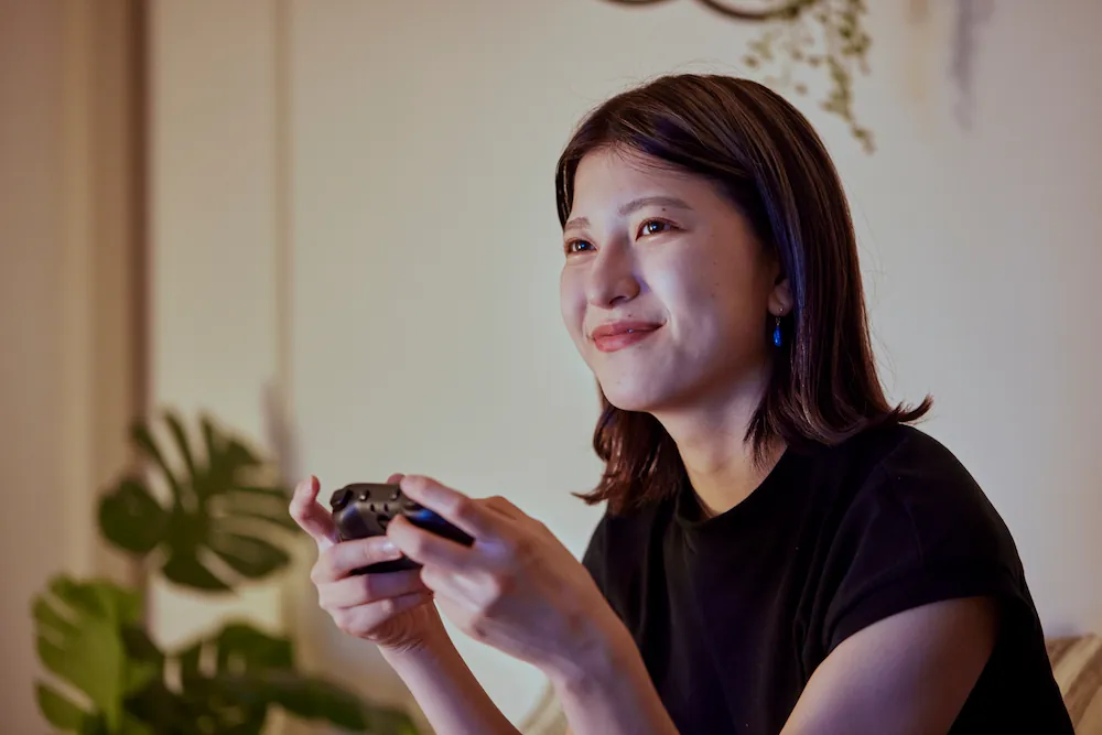 自宅でオンラインゲームを楽しむ女性のイメージ画像
