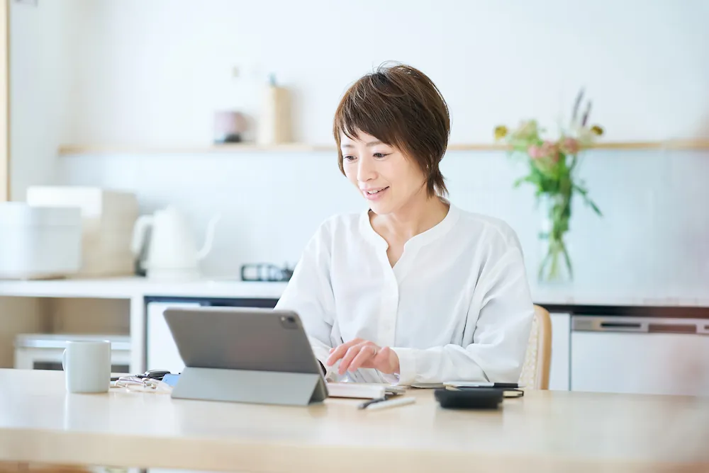 ノートパソコンでメールやインターネットを利用する女性のイメージ画像