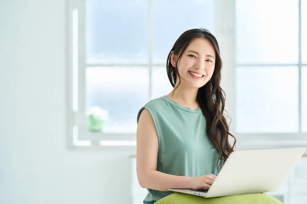 ノートパソコンでインターネットを利用する女性のイメージ画像